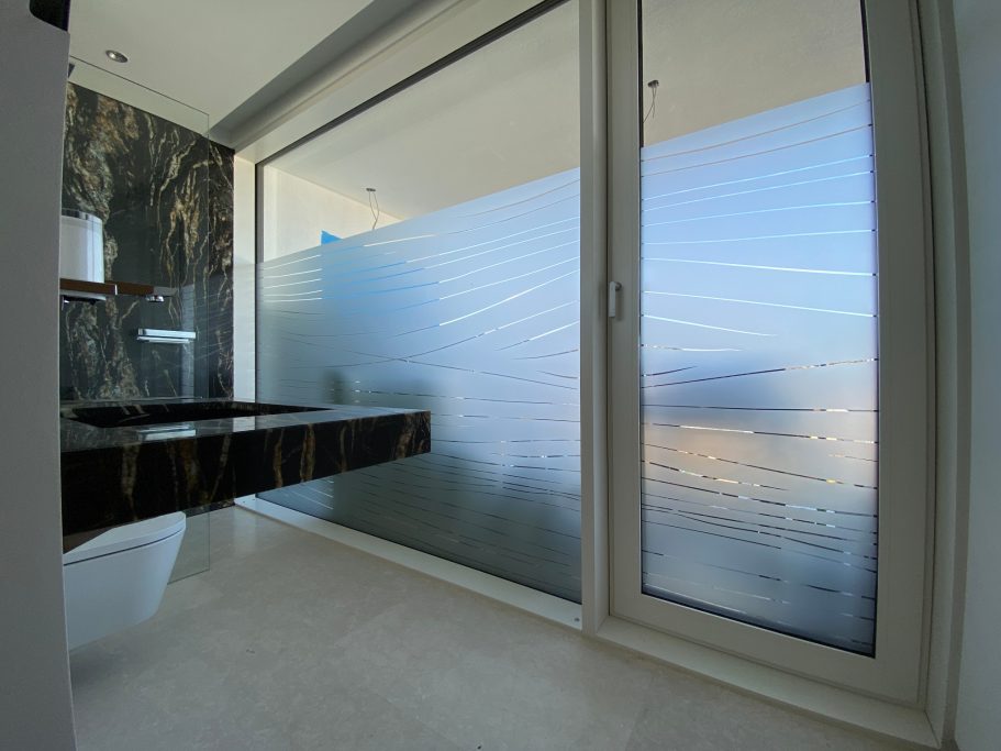 Modernes Badezimmer mit Fenstern und einer minimalistisch gestalteten Ablage.