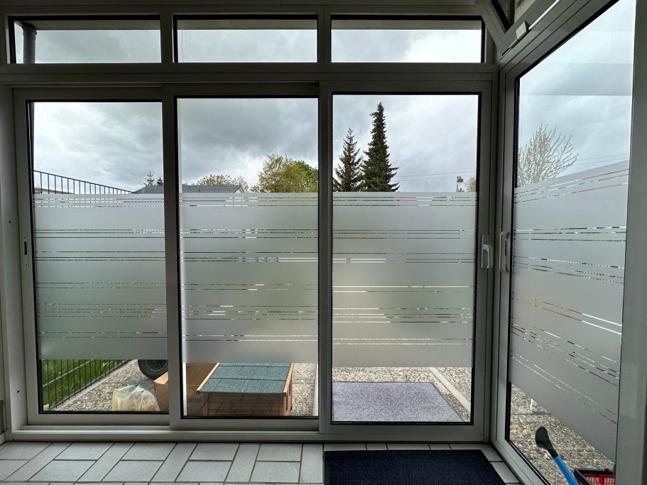 Fenster mit milchigem Glas, blickdicht und leicht beschlagen, davor eine Terrasse.