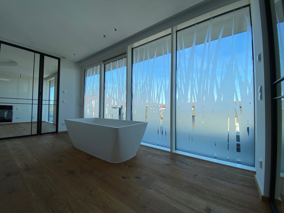 Helles, modernes Zimmer mit großen Fenstern und freistehender Badewanne.