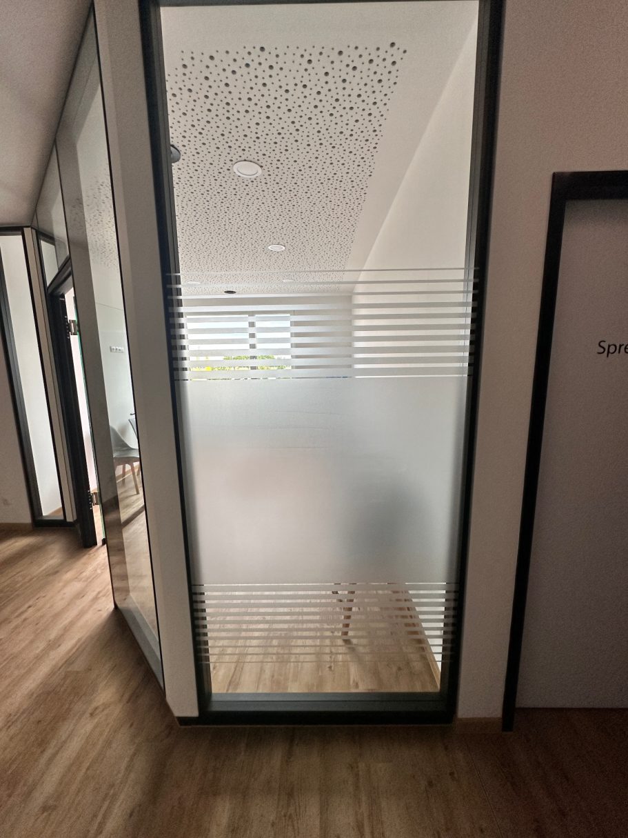 Glaswand mit milchigem Effekt, Blick in ein helles, moderndes Bürozimmer.