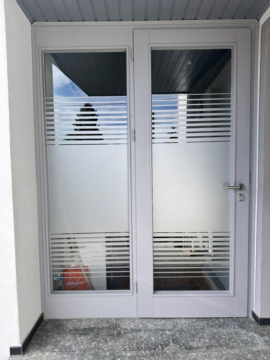 Weißes Türpaar mit Glas und horizontalen Streifen, vor einem hellen Hintergrund.